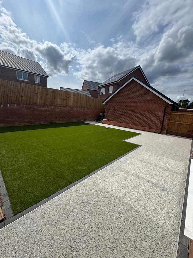 Resin bound path and patio, bordered by block paving and an artificial grass lawn.